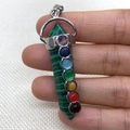 Green malachite hexagonal prism 7 chakra crystal pendant with silver clasp in hand - Malachite