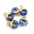 Vijf blauwe stenen hangers met gepolijste gouden ogen op een heldere witte achtergrond - Ronde Ring / Sodaliet