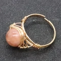 Handmade wire wrapped ring with a round pink orange gemstone and gold adjustable band - Pink Aventurine