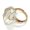 Dettaglio macro dell'anello regolabile fatto a mano in filo dorato e cristallo naturale - N. 10 (Bianco)