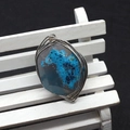 Macro detail of handmade wire-wrapped blue agate natural stone pendant on a wooden stand - Blue