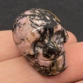 Sculpture de crâne en pierre rhodonite polie avec texture naturelle rose et noire - Rhodonite avec Lignes Noires