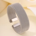 Dettaglio di un bracciale aperto in acciaio al titanio intrecciato argento con trama a rete - Versione Larga / Argento