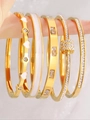 Gros plan de bracelets en acier doré sertis d'émail blanc et de zircons brillants - White Heart Enamel Set