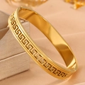Detailed close-up of gold-plated stainless steel bangle with Greek Key pattern engraving - Gold