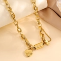 Goldene grobe Gliederkette mit Herzanhänger und zylindrischem Metallelement - Halskette / Gold