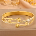 Détail d'un bracelet en acier doré avec motifs d'étoiles et cristaux scintillants - Style Étoile à Huit Branches Dorée / Or