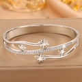 Détail du bracelet manchette argenté avec étoiles en zircons et design vague - Style étoile à huit branches couleur acier / Acier