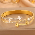 Macro détaillée d'un bracelet trèfle doré avec des cristaux sur un fond de satin - Style Trèfle à Quatre Feuilles Bicolore / Bicolore (Or & Argent)