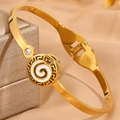 Gros plan détaillé du bracelet en acier doré avec motif grec et spirale en émail blanc - Bracelet Cercle Émail Blanc Doré
