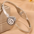 Gros plan détaillé du bracelet en acier avec motif grec et spirale en émail blanc - Bracelet rond émaillé blanc couleur acier