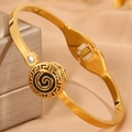Gros plan sur un bracelet en acier doré avec motif grec et détails en émail noir - Bracelet Cercle Émail Noir Doré