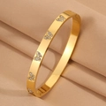 Vue détaillée du bracelet en acier titane doré orné de cinq papillons sertis de diamants - Papillon Blanc