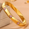 Detailansicht eines vergoldeten Armreifs mit drei pinkfarbenen sternförmigen Kristallen - Gold Stern Rosa Zirkonia