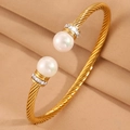 Vue détaillée du bracelet doré torsadé avec perles blanches et accents de strass brillants - Perle Dorée