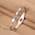 Détail d'un bracelet en acier inoxydable argenté avec strass floraux et fermoir latéral - Style Étoile Multicolore Argent