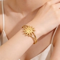 Detail of a smiling sun gold bangle on a wrist with a polished cutout double-line design - Sunflower Smiley / Gold
