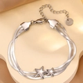 Vue macro d'un bracelet triple chaîne serpent argenté avec pendentifs étoiles polies - Bracelet Étoile Trois Couches Argent