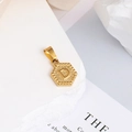 Vue détaillée du pendentif hexagonal doré avec motifs radiaux et lettre D embossée - Lettre D