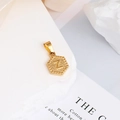 Macro di un ciondolo esagonale in oro 18K con lettera Z incisa e finitura testurizzata - Lettera Z