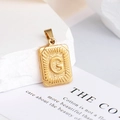 Detail van vergulde letter G hanger met radiale textuur en rechthoekig frame - Letter G