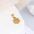 Pendentif hexagonal doré avec relief lettre B sur un fond de pierre blanche brute - Lettre B