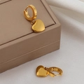 Détail de boucles d'oreilles cœur dorées sur écrin avec éclat métallique élégant - Boucles d'Oreilles Créoles Pendentif Coeur Doré