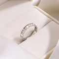 Macro shot of a minimalist titanium steel ring with sparkling pavé zircons in a box - US 7 / Silver
