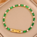 Détail du bracelet tennis doré avec pierres vert émeraude et zircons sur un support - Vert + Blanc