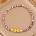 Gros plan d'un bracelet tennis doré avec zircons violets et fermoir à rabat sûr - Violet + Blanc