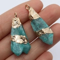 Irregular blue crystal stone pendant with gold foil wrap finish held by hand - 10x30-15x50mm