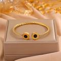 Bracelet torsadé doré avec motif grec noir et extrémités rondes sur écrin bijoux - Motif Cercle Noir