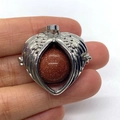 Silver winged heart pendant featuring a round gold sand stone inlay on hand - Gold Sandstone