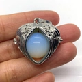 Silver angel wing heart pendant with translucent white opal bead in handheld view - Opal
