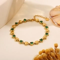 Golden heart link bracelet featuring green gemstones and a stainless steel lobster clasp - Heart Green Zirconia Hollow Bracelet