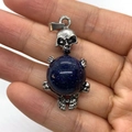 Vintage silver skull pendant holding a glittering blue sandstone sphere on a hand - 20x42mm / Blue Sandstone