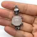 Silver skull pendant with white opal stone held in hand for size visualization - 20x42mm / White Crystal