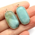 Amazonite oval stone pendants with gold plated edges shown in hand for size context - 15x30mm, 5g / Amazonite