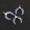 Three crescent opalite pendants with gold metal loops on dark background - Opal