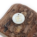 Macro view of natural white shell pendant with golden letter E for DIY jewelry - Letter E