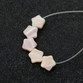 Makroaufnahme von fünf sternförmigen Perlmutt-Perlen in Rosa für die Schmuckherstellung - 6-7MM / Stern / Rosa