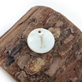 Detailed close-up of natural shell pendant with golden letter I on a wooden block - Letter I