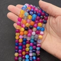 Mix colored striped agate beads in 8-10mm size being held in hand for jewelry making - Colorful Stripe (No. 7)