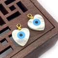 Vue macro de pendentifs en nacre en forme de cœur avec incrustation d'œil sur bois - Cœur Plat 10mm