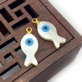 Vue macro de deux pendentifs en nacre en forme de poisson avec œil porte-bonheur bleu - Poisson 8x15mm
