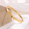 Titanium gold cross bracelet with emerald green pendant and white zircons on silk background - Gold Irregular Bangle