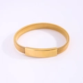 Macro view of gold minimalist stretch spring bracelet with a smooth polished metal plate - Gold
