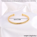 Vista detallada de la textura de cuerda retorcida y el diámetro de 6 cm del brazalete dorado - Dorado Abierto (Espiral)