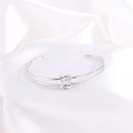 Detalle del brazalete abierto con nudo plateado y texturas metálicas pulidas y trenzadas - Plateado Abierto (Nudo)