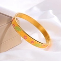 Detail van een gouden emaille armband met roze bloempatronen op een witte zijden achtergrond - Geel met Roze Bloem Stijl / Goud
